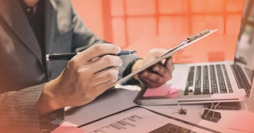 polite payment chasing credit controller making notes in clipboard with laptop