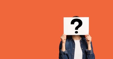 person holding question mark sign with orange background about supplier and payroll payments