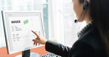 Woman at computer reviewing invoices that need to get paid.