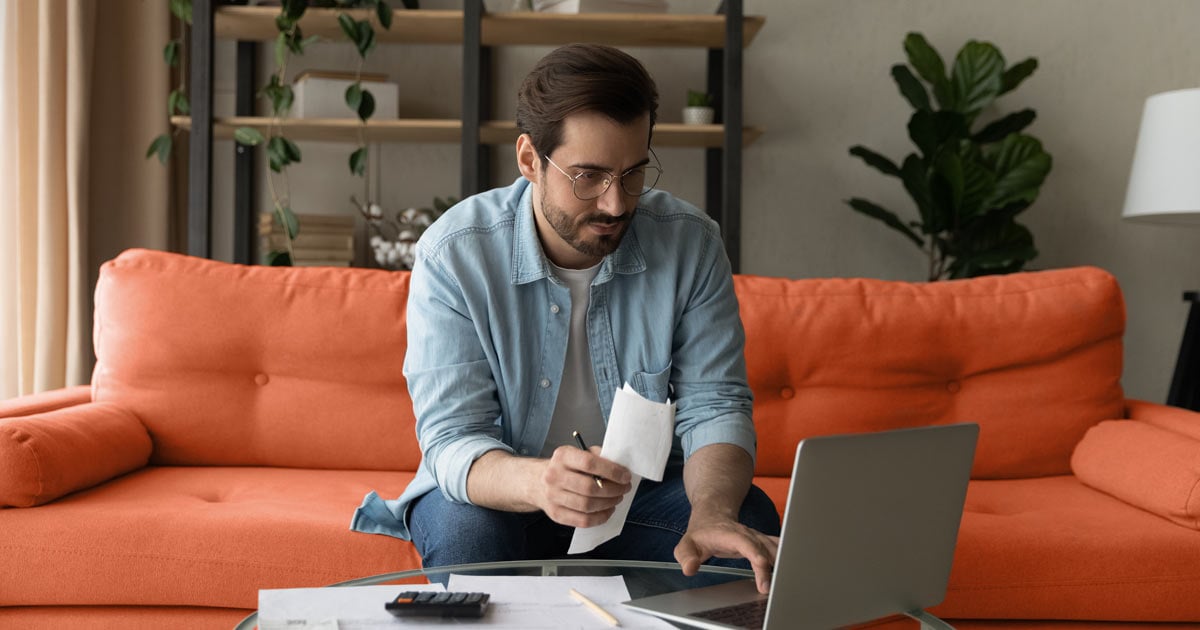 man seating in an orange sofa searching on his laptop on what is trade receivables and why is it important 