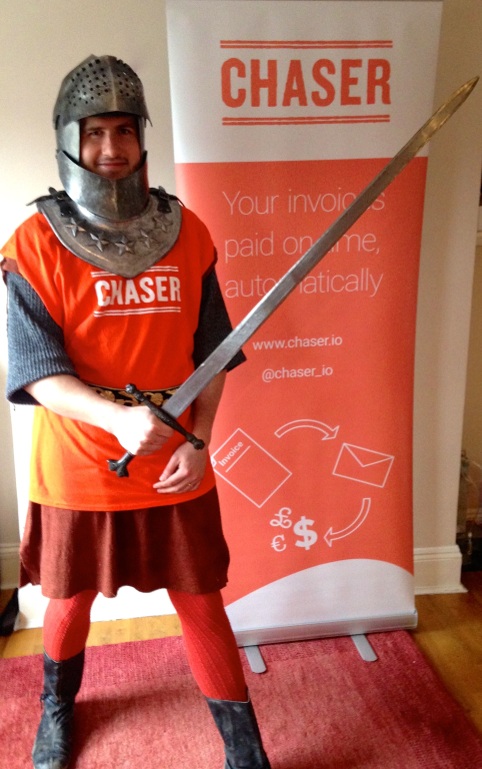 Sir Chasealot in full medieval attire, brandishing a sword in front of an orange Chaser banner