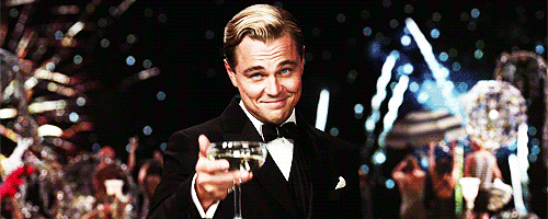 Animation of Leonardo DiCaprio's Jay Gatsby smiling and raising a glass of champagne in front of a background of fireworks from the 2013 Baz Luhrmann film The Great Gatsby
