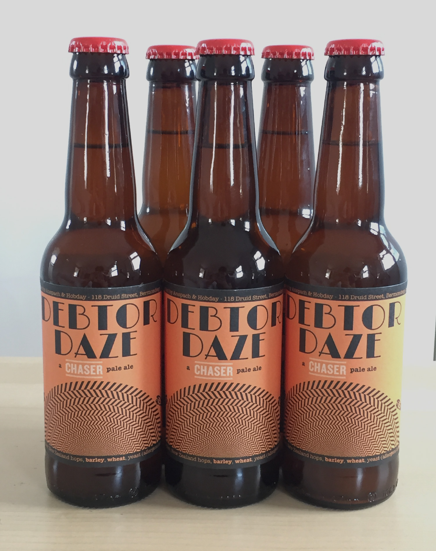Five bottles of orange-labelled Debtor Daze pale ale lined up